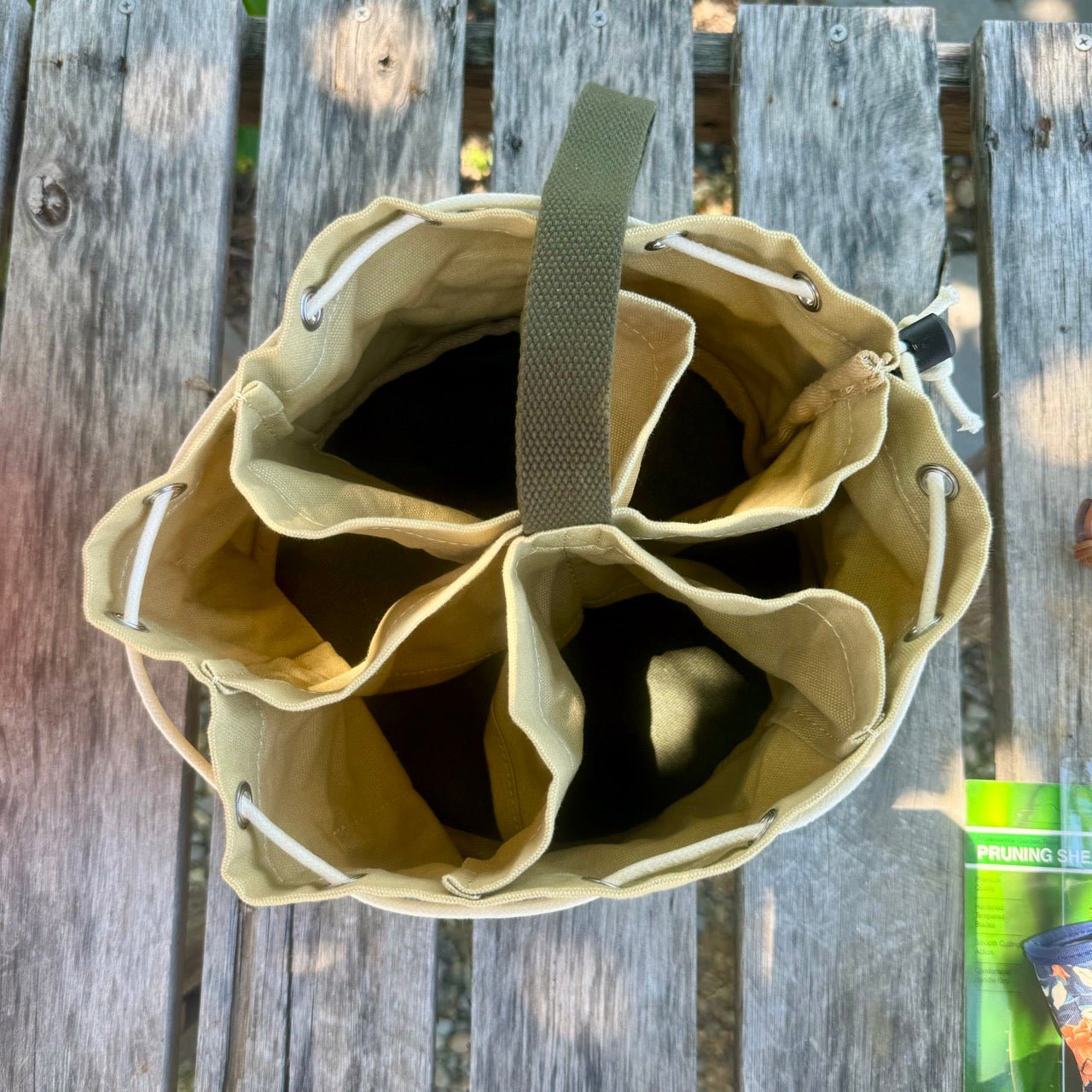 Beige drawstring bag on a wooden surface with a green can in the background