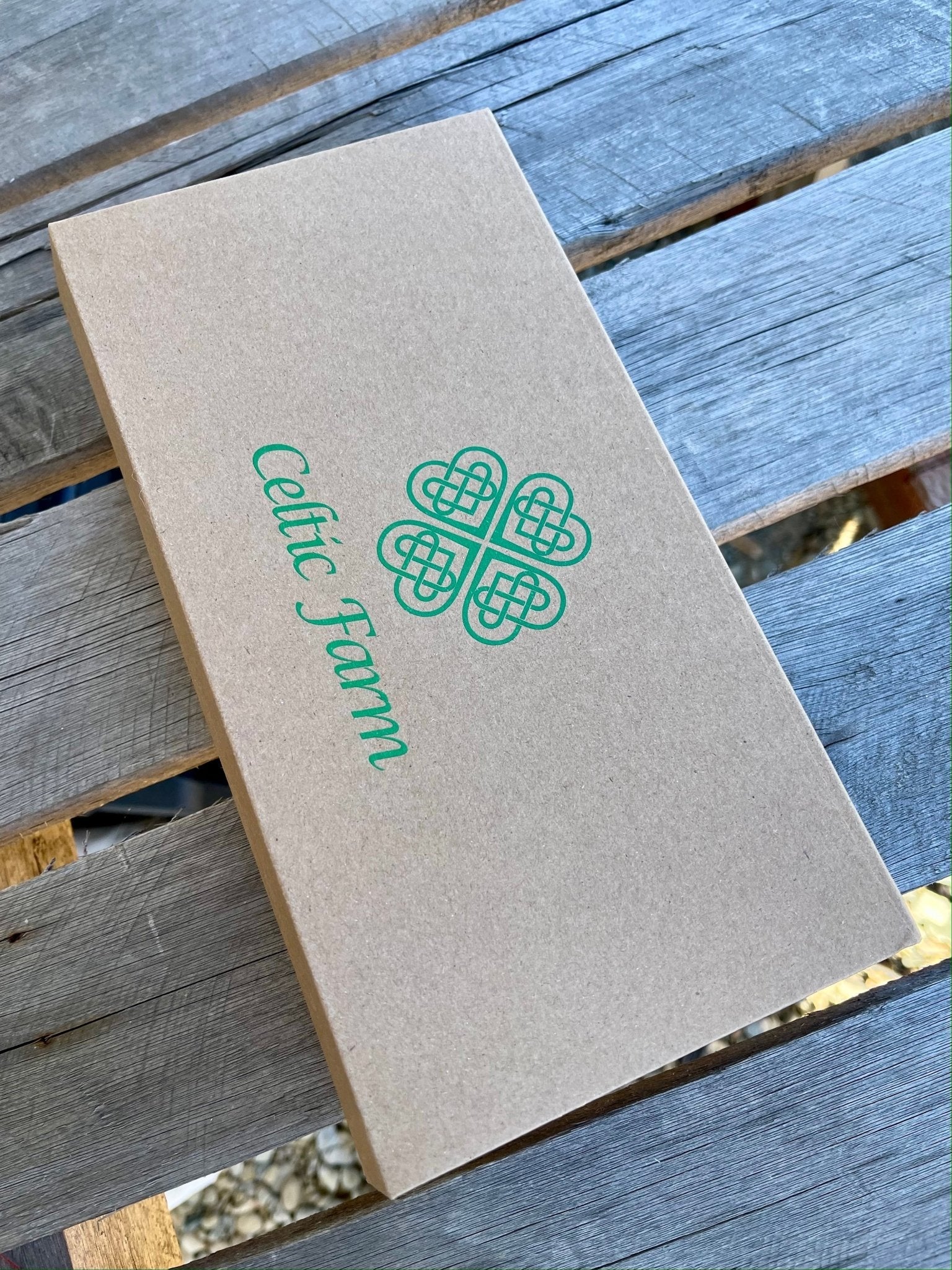 Brown paper bag with 'Celtic Farm' logo on a wooden surface