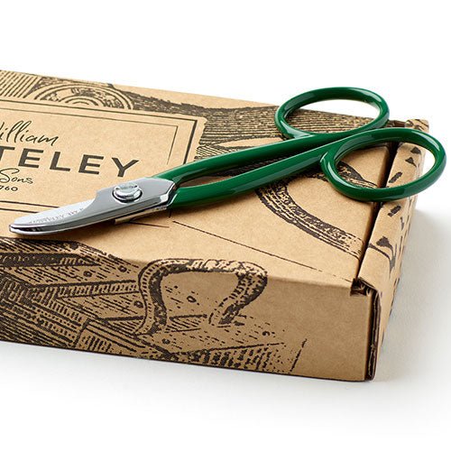 Green scissors on a cardboard box with 'W. Teely' branding